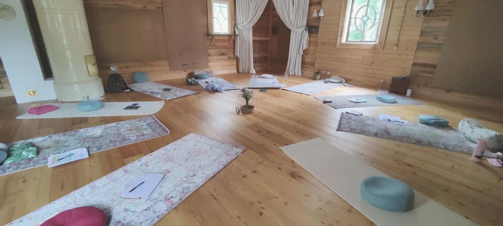 Joogasali Guru Ram Dasin talossa: joogamatot ja tyynyt valmiina puulattialla.